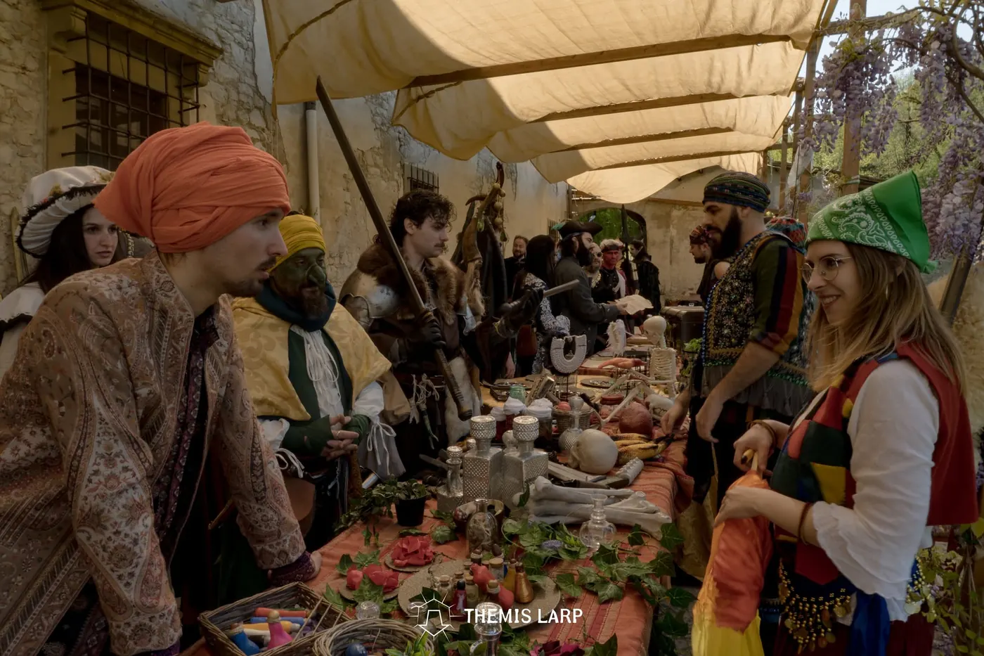 Partecipanti in costume durante una scena di mercato nell’evento LARP Themis