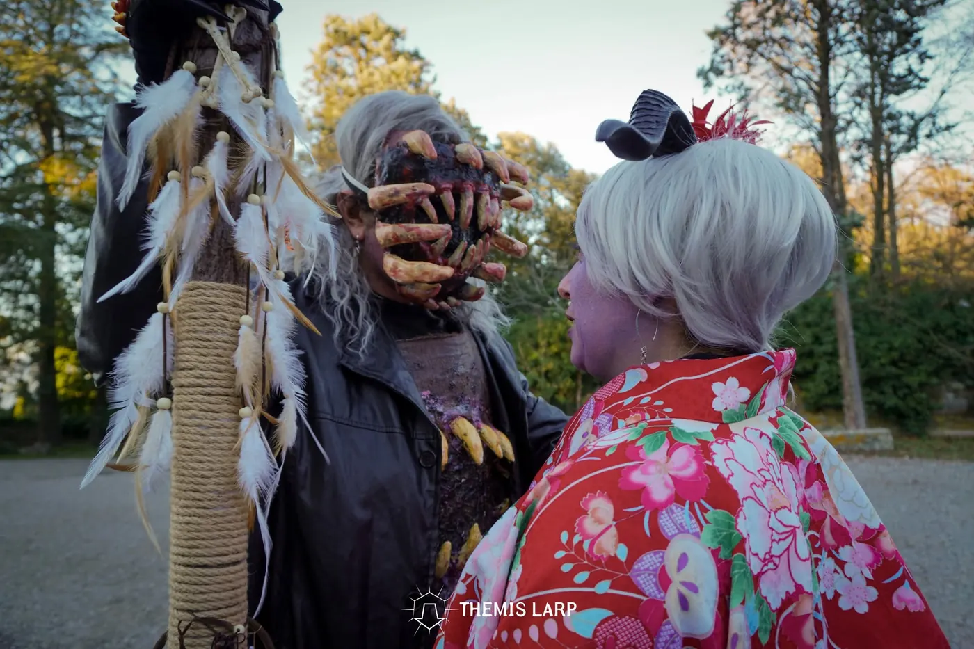 Creatura mascherata con elementi ossei e piume durante un evento Themis